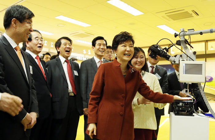 ▲ 지난해 12월 17일 포항창조경제혁신센터를 찾은 박근혜 대통령이 기기를 직접 작동해 보며 환하게 웃고 있다.