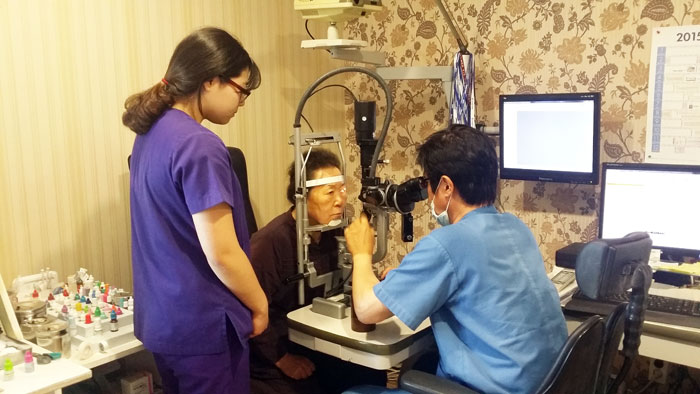 ▲ 영동안과의원 이우석 원장이 최근 수술한 환자의 눈 상태를 확인하고 있다.