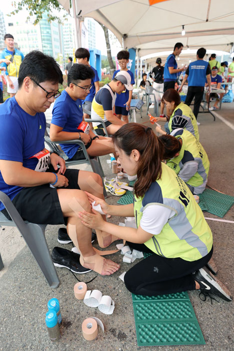 ▲ 에스포항병원 직원들이 참가자들에게 스포츠 테이핑 자원봉사를 하고 있다.