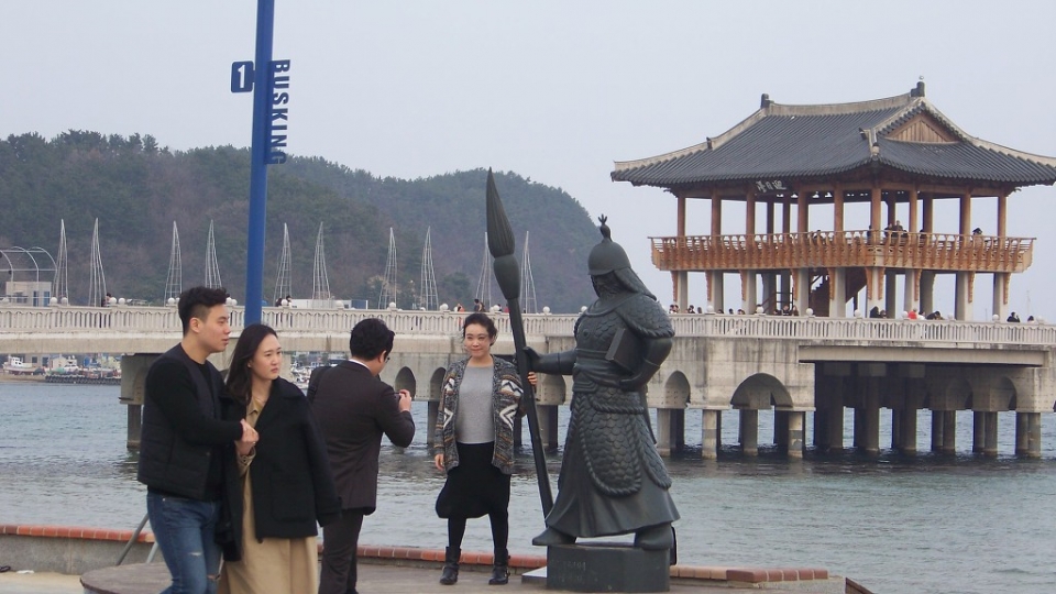 칼 대신 붓을 든 이순신 장군 동상을 배경으로 기념촬영하는 나들이객들.