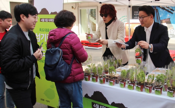 가수김장훈과 독도홍보전문가 서경덕 성신여대교수가 독도식물 섬기린초를 나눠주고 있다.