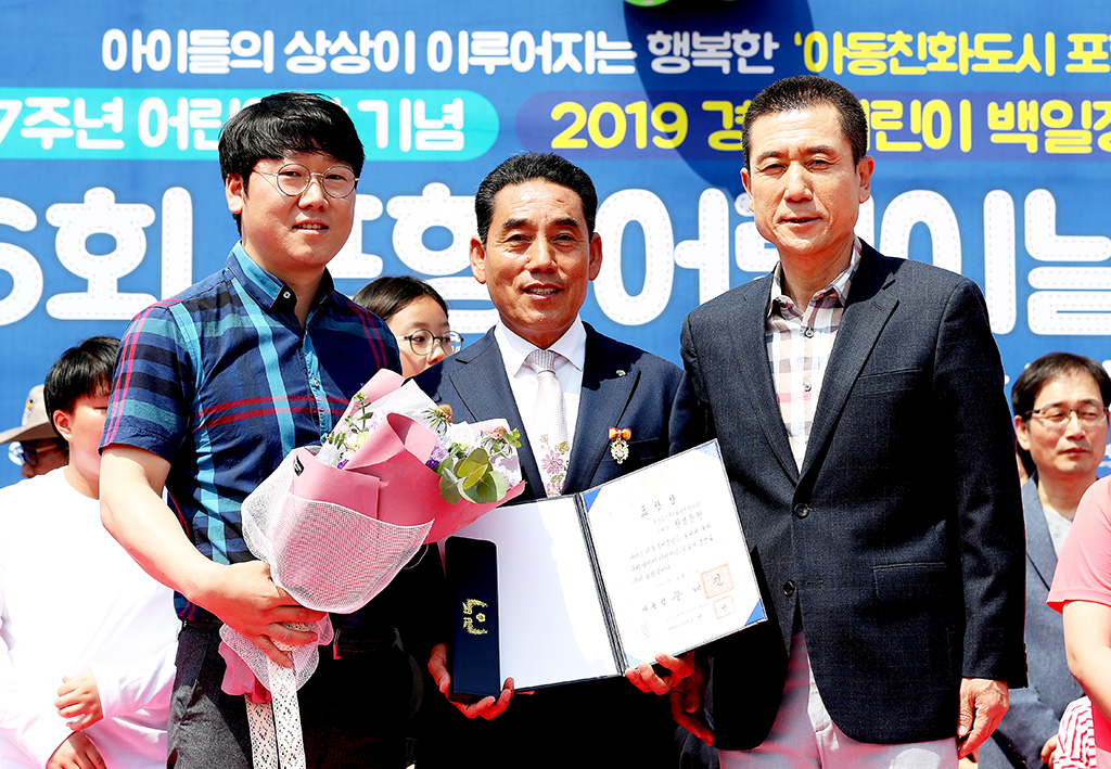 구룡포 지역사회 보장협의체 황보관현 위원장(가운데)아 아동복지증진 공로를 인정받아 대통령 표창을 받고 있다.