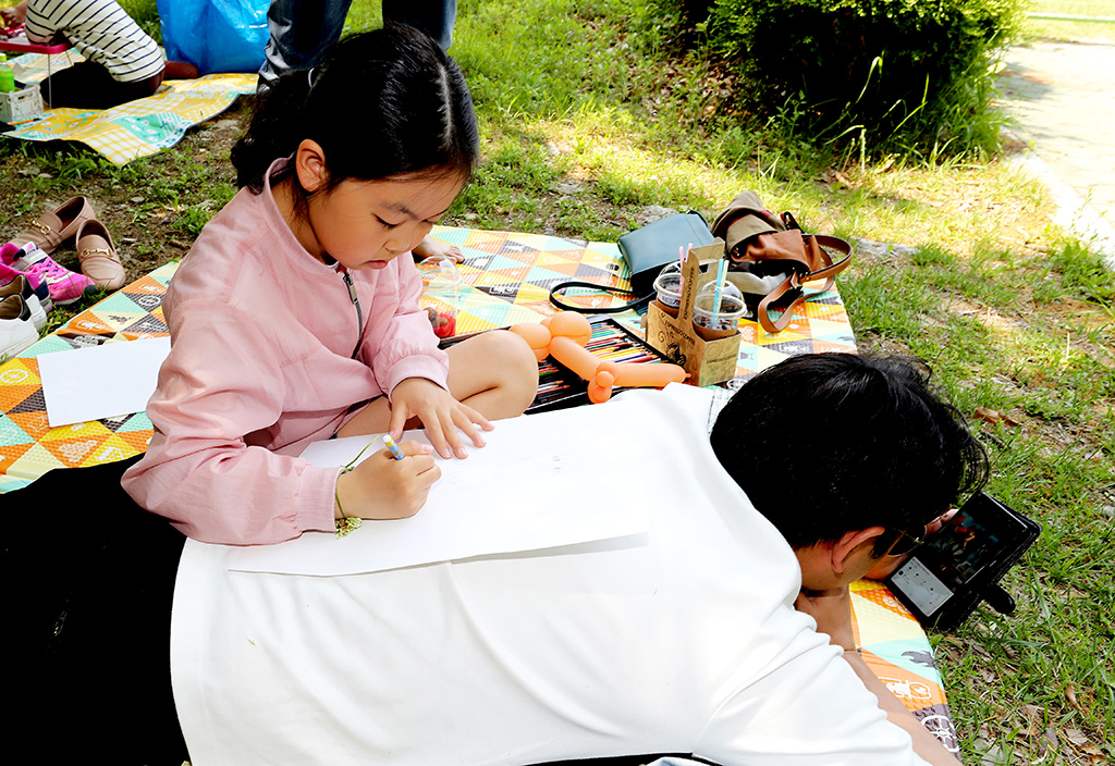 5일 오전 경주 황성공원에서 한 어린이가 아빠의 넓은 등을 책상 삼아 그림 솜씨를 뽐내고 있다.