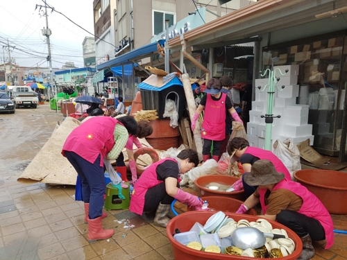 태풍 '미탁'이 지나간 4일 경북 울진군 울진읍 울진시장 내 한 그릇 가게에서 자원봉사자들이 정리를 돕고 있다.