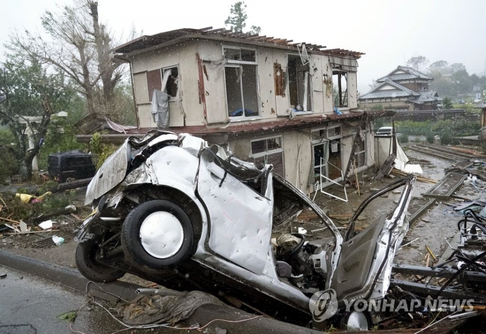 12일 제19호 태풍 하비기스가 일본에 접근하고 있는 가운데 일본 시즈오카(靜岡)현 이치하라(市原)시에서 돌풍에 의해 차량이 넘어져 있다. 그 뒤로는 파손된 주택도 보인다.