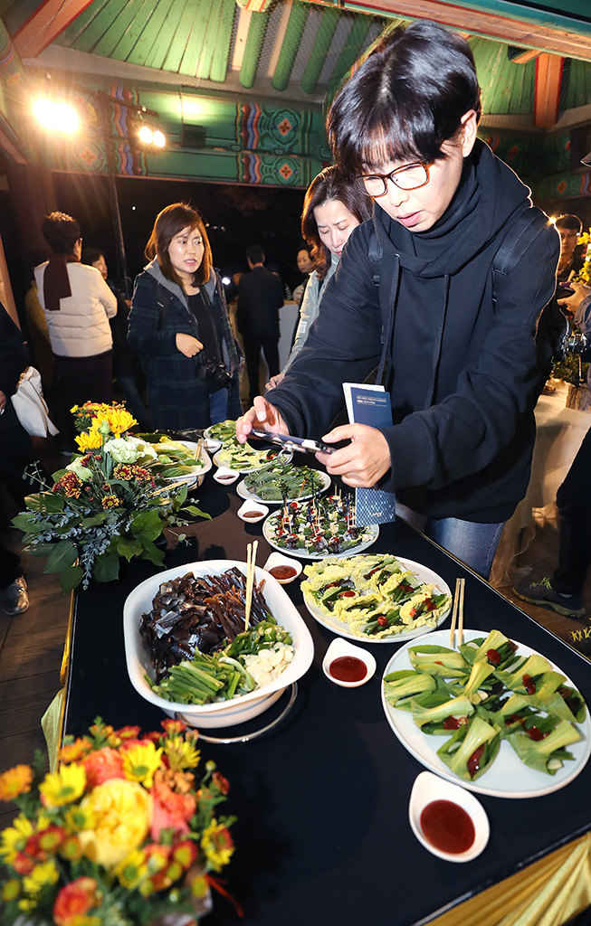 구룡포 과메기 홍보행사에 참가한 시민들이 다양한 과메기 요리를 카메라에 담고 있다.