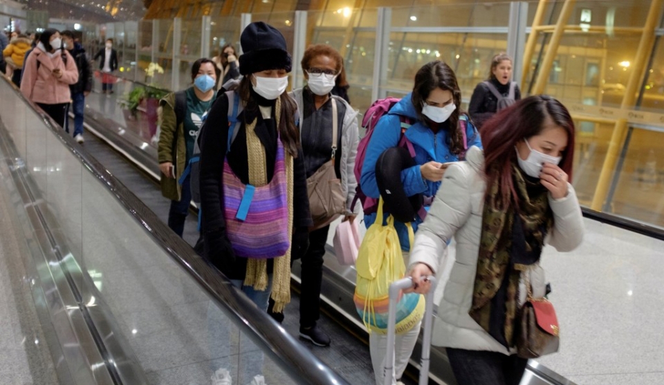 25일 중국 베이징 공항에 도착한 여행객들이 마스크를 쓴 채 에스컬레이터를 타고 이동하고 있다.