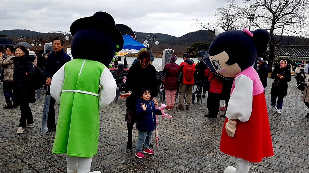 호반광장에서 어린이가 선비투어 캐릭터와 즐기고 있다.