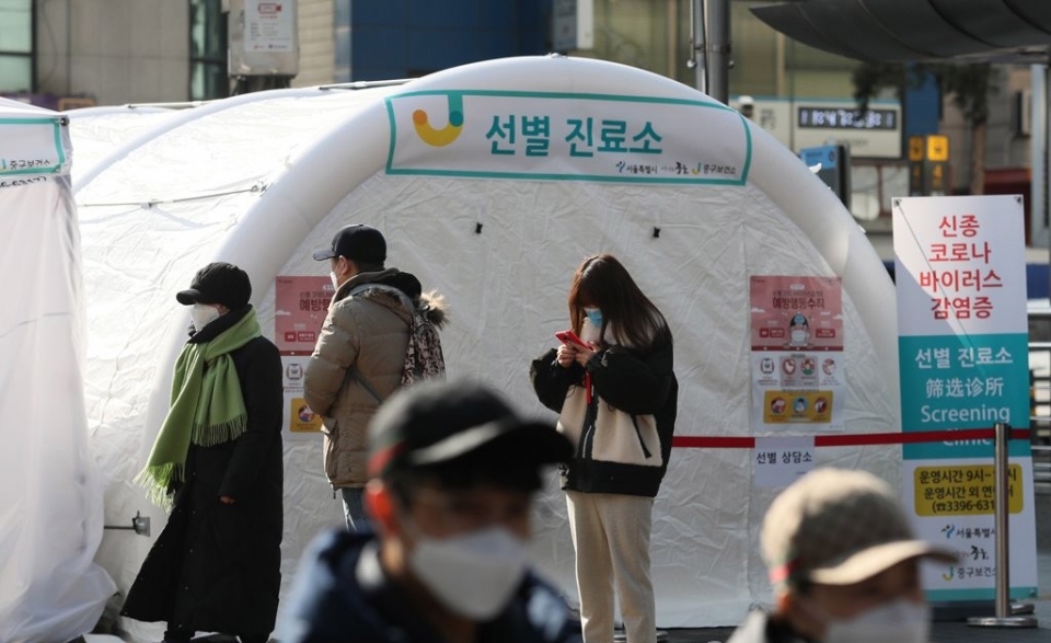 3일 서울 중구 명동역 인근 거리에 신종 코로나바이러스 감염증의 유입과 확산을 방지하기 위해 설치된 중구보건소 선별진료소 앞으로 관광객과 시민들이 지나고 있다.