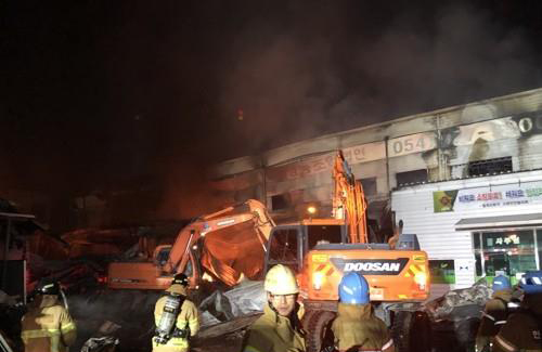 12일 밤 경북 칠곡군 동명면의 한 영농조합법인 공장에서 화재가 발생했다. 소방관들이 화재 현장에서 큰 불길을 잡고 잔불 정리를 하고 있다.