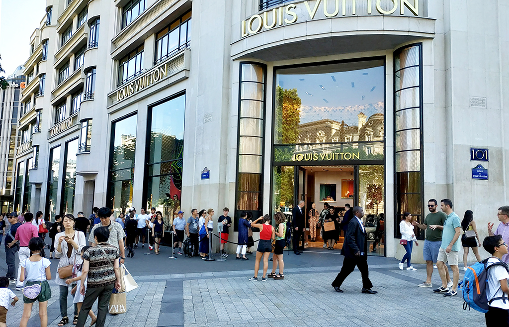 샹젤리제 거리의 루이뷔통 매장에 들어가기 위해 관광객들이 길게 줄을 서서 기다리고 있다.