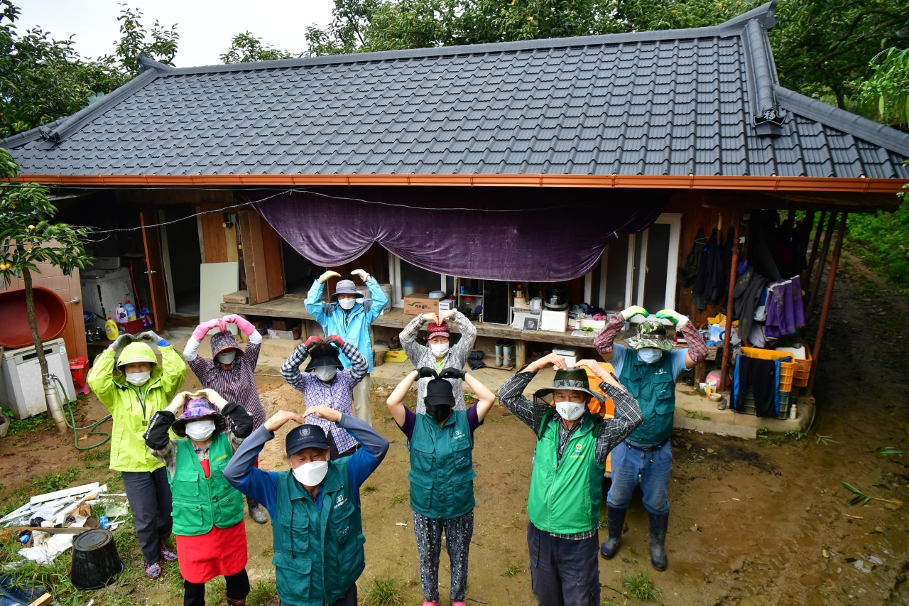 청도군 새마을회의 도움으로 집 수리가 된 A씨의 집 마당에서 매전면 새마을회 회원들이 기쁨을 표시하고 있다.