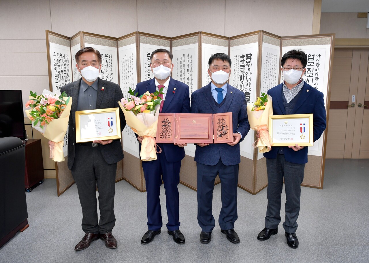 진후진, 황재용, 이정걸 시의원들이 김창기(왼쪽 세번째)의장에게 유공 표창을 전수받고 기념 촬영을 하고 있다. /문경시의회제공