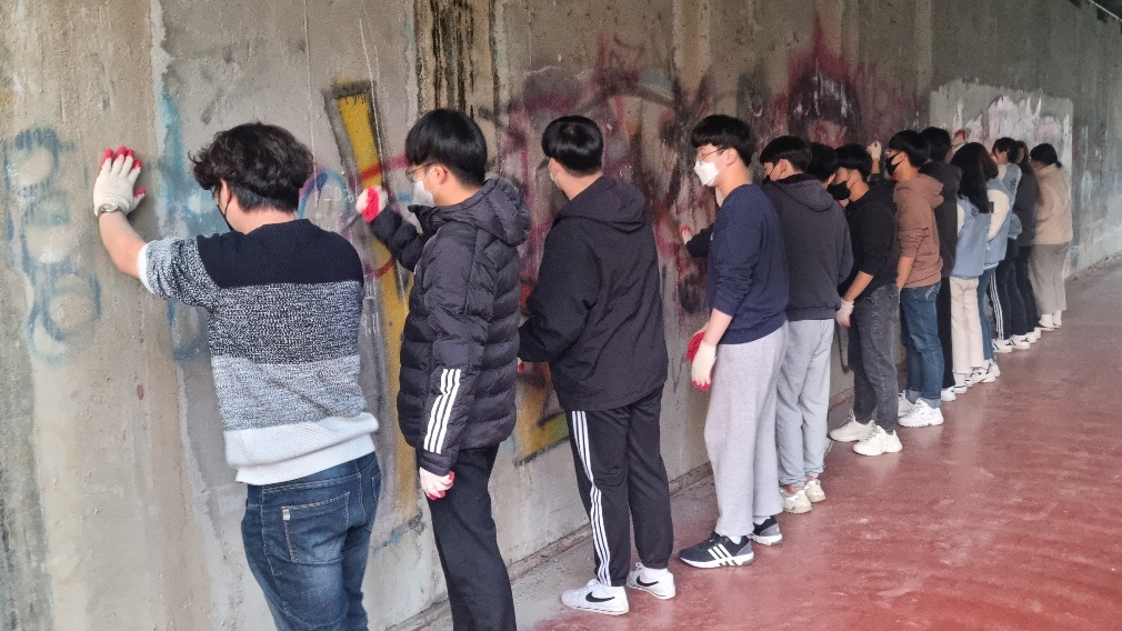 무학교 벽화 그리기 프로젝트에 참여한 대구가톨릭대 역사교육과 학생들이 그림을 그리기에 앞서 낙서를 지우고 있다. (사진 제공: 대구가톨릭대 역사교육과)