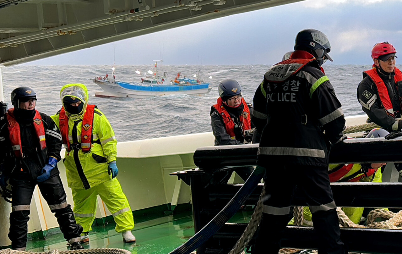 기관고장으로 표류중인 어선에 접근한 경비함정의 승무원들이 예인을 위한 밧줄을 점검 하고 있다./ 동해해경제공