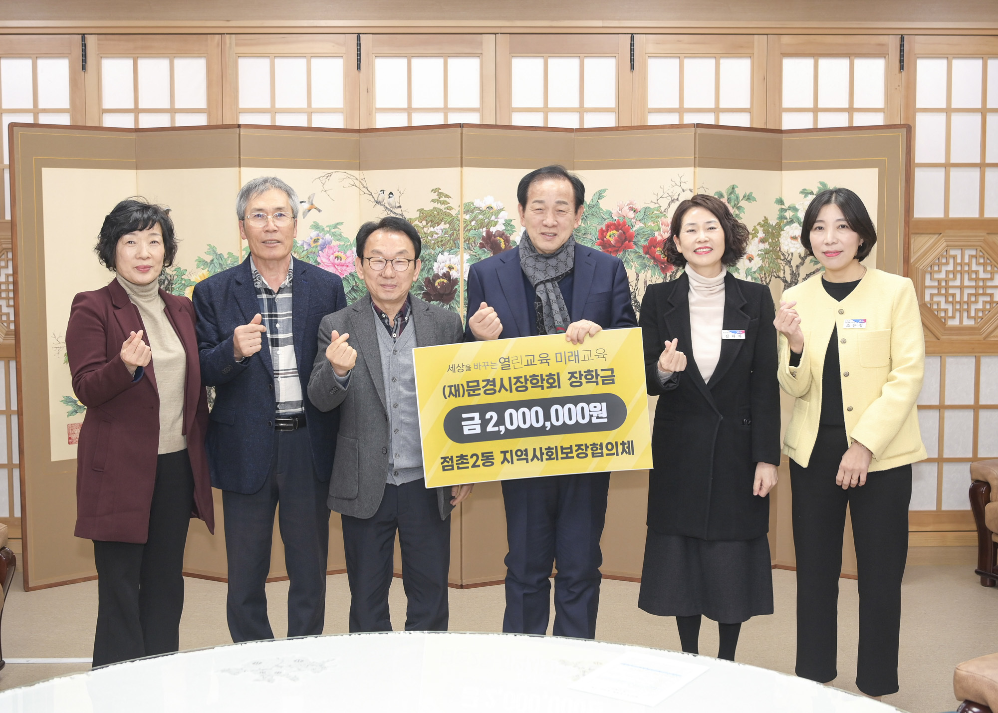 문경시 점촌2동 지역사회보장협의체 회원들이 신현국 문경시장에게 장학금을 전달하고 있다. /문경시제공